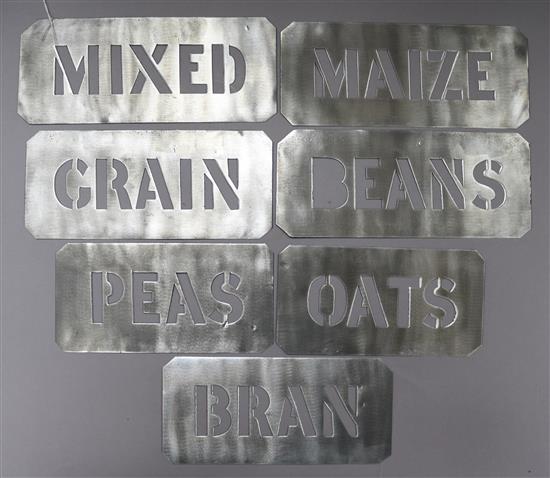 Seven tin grain stencil signs